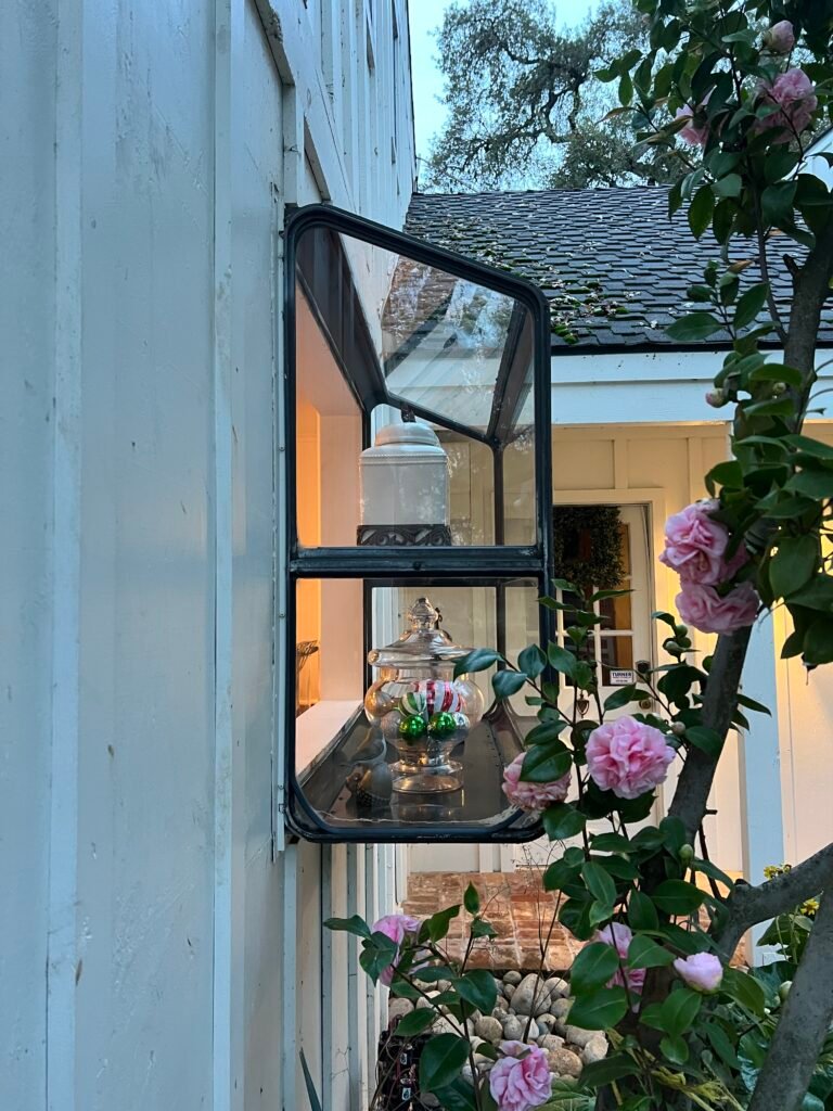 Outdoor wall light fixture beside climbing roses
