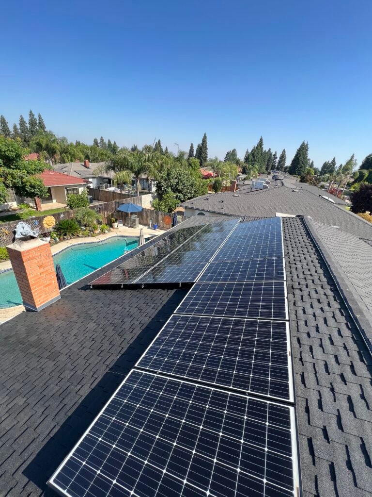 Rooftop solar array on a shingle roof with a backyard pool below