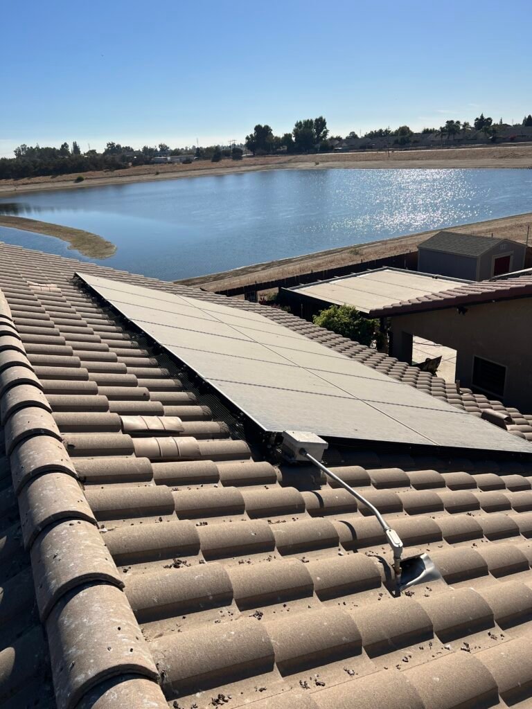 Solar panels on a tile roof overlooking a neighborhood lake