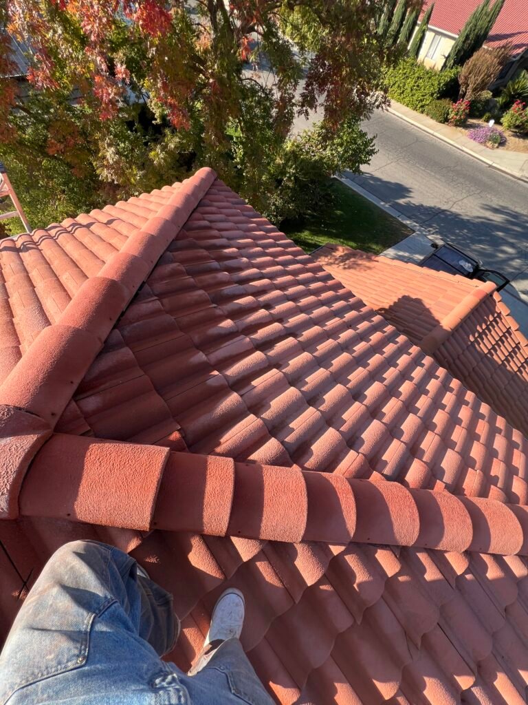 Ducky's technician on a red clay tile roof during roof cleaning