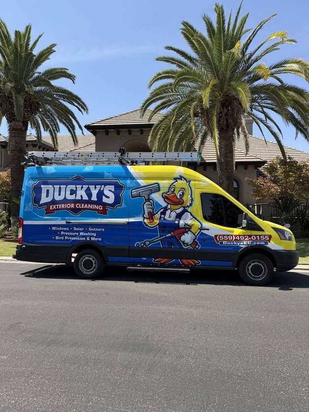 Ducky's Exterior Cleaning van parked in front of a Fresno home with palm trees